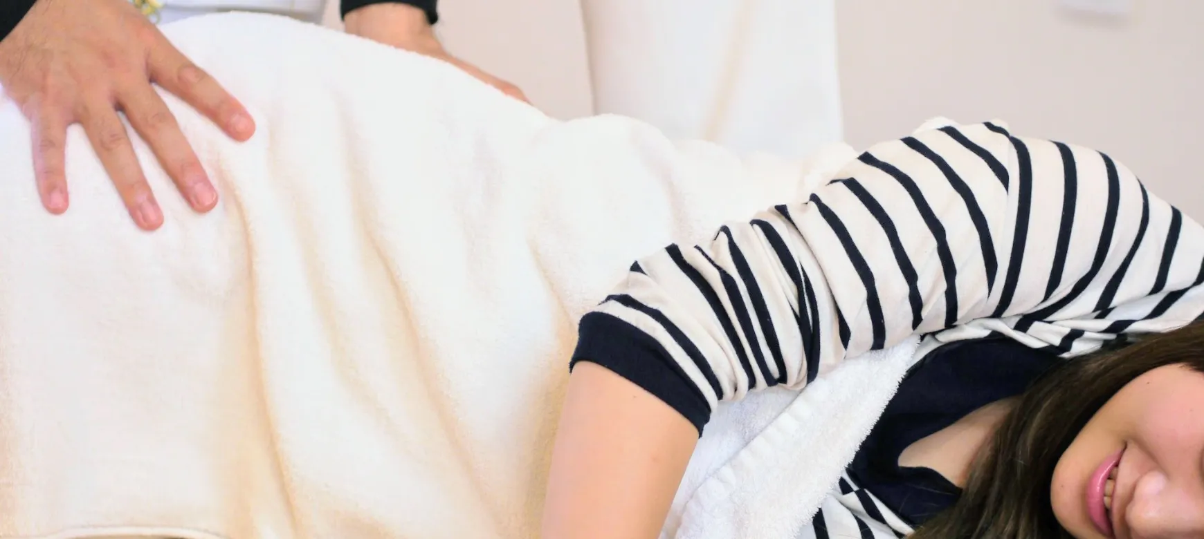 横向きで腰まわりの施術を受ける女性｜ひまわり接骨院 整体院 瀬戸店